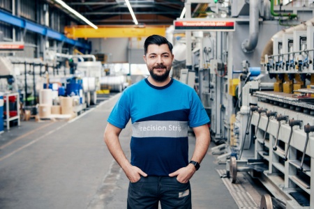 Mann mit Klemmbrett in der Hand schaut durch Stahlröhre